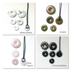 May include: Assortment of five donut-shaped pendants made of various stones, including white howlite, unakite, rose quartz, and Chinese obsidian. Each pendant is strung on a black cord.
