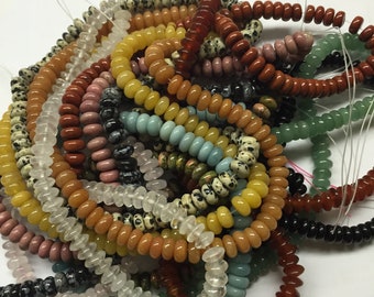 May include: A collection of colorful gemstone beads, including yellow, orange, red, pink, green, black, and white. The beads are all round and have a smooth, polished finish. They are strung on a thin wire and are ready to be used for jewelry making.