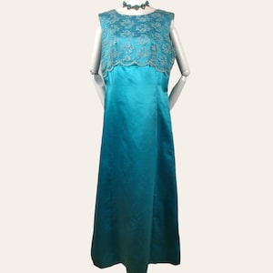 May include: A turquoise sleeveless maxi dress with a white lace bodice. The dress has a simple, elegant design and is perfect for a formal occasion.