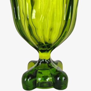 May include: A green glass bowl with a fluted design and a four-legged base.