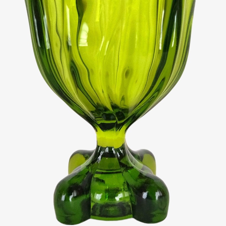 May include: A green glass bowl with a fluted design and a four-legged base.