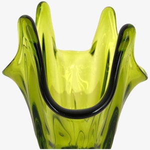 May include: A green glass vase with a unique, wavy design. The vase has a wide opening and a narrow base.