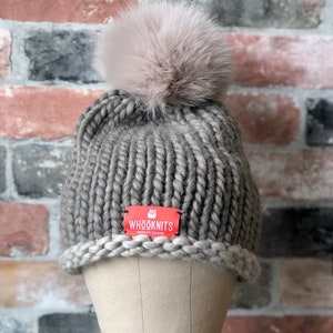 El WHōōKNITS &quot;Tilly&quot; Sombrero de lana Merino tejido a mano: Sombrero de lana 100% con pom pom de piel