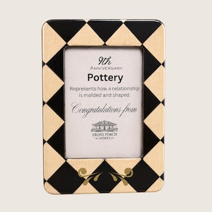 Puede incluir: Un marco de fotos rectangular con un borde de patrón de diamantes en negro y beige. La inserción central muestra el texto 9th Anniversary Pottery, Represents how a relationship is molded and shaped, Congratulations from y Front Porch Homes.