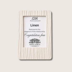 Puede incluir: Un marco de fotos rectangular de color blanco roto con un patrón texturizado vertical. El inserto dice: 12th Anniversary, Linen, Represents the elegance of the relationship, Congratulations from, con una ilustración de una casa y el texto Front Porch Homes.