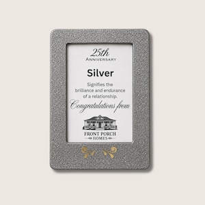 Puede incluir: Un marco rectangular de tono plateado con acabado texturizado que contiene una tarjeta blanca con el texto 25th Anniversary, Silver, Signifies the brilliance and endurance of a relationship, Congratulations from, Front Porch Homes, y dos adornos dorados.