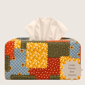 May include: A rectangular fabric tissue box cover featuring a patchwork design of various floral and checkered patterns in shades of yellow, red, green, and blue. A white tissue is pulled through the top. A star-shaped label reads Large Tissue Box Covers.