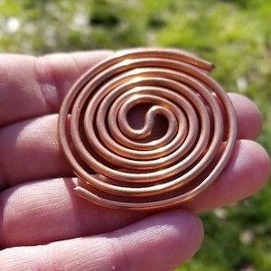 May include: A copper spiral, or coil, with a double spiral design. The spiral is made of thick copper wire and is about 3 inches in diameter.