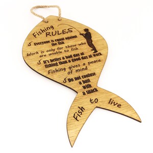 The fishing rules are made of wood. The laser-cut fish-shaped board is engraved with various fishing rules. The rules come with a linen cord for hanging.