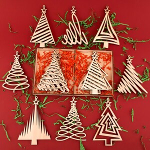8 Christmas trees of different ornaments are placed next to the wooden box. Laser-cut Christmas trees are also available in the box.