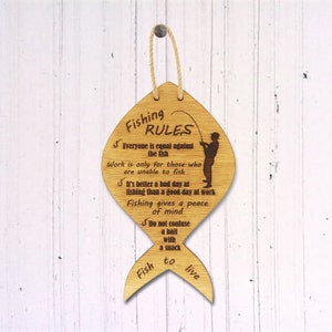 The fishing rules are made of wood. The laser-cut fish-shaped board is engraved with various fishing rules. The rules come with a linen cord for hanging.