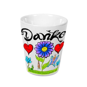 Könnte beinhalten: Weiße Keramiktasse mit schwarzer "Danke"-Inschrift und einer bunten Blume mit Schmetterling und Raupe. Die Tasse hat zwei rote Herzen mit dem Text "For Name" und "From Name".