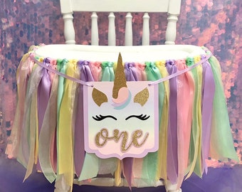 Guirnalda para silla alta de primer cumpleaños con unicornio y cintas en tonos pastel.