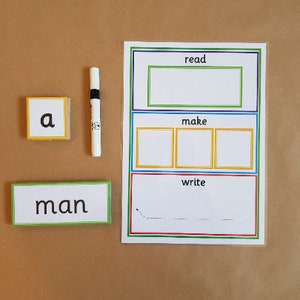 May include: Educational learning tools for children. Includes a white board with the words "read", "make", and "write", along with a marker, and word and letter cards. The word card says "man" and the letter card says "a".