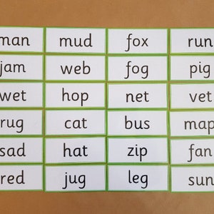 May include: A collection of flashcards with words printed on them. Each card has a white background with a green border. The words include "man", "mud", "fox", "run", "jam", "web", "fog", "pig", "wet", "hop", "net", "vet", "rug", "cat", "bus", "map", "sad", "hat", "zip", "fan", "red", "jug", "leg", and "sun".
