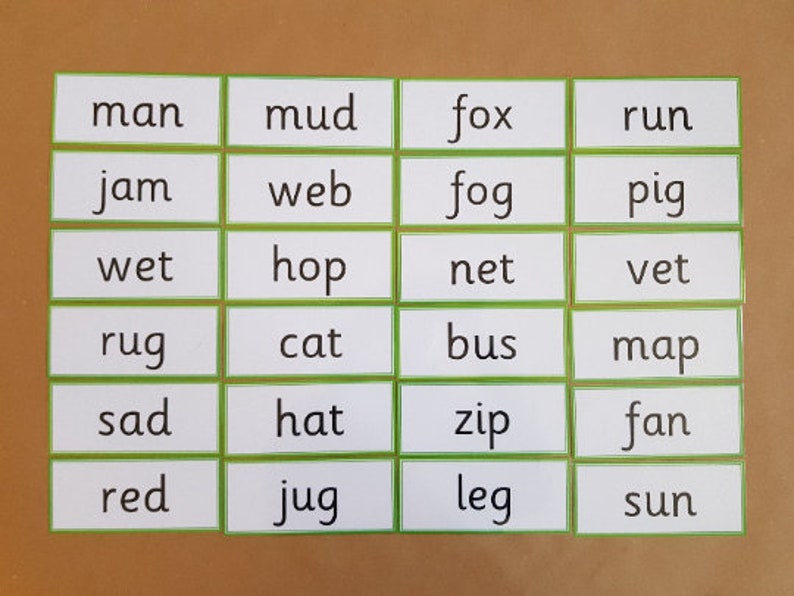 May include: A collection of flashcards with words printed on them. Each card has a white background with a green border. The words include "man", "mud", "fox", "run", "jam", "web", "fog", "pig", "wet", "hop", "net", "vet", "rug", "cat", "bus", "map", "sad", "hat", "zip", "fan", "red", "jug", "leg", and "sun".