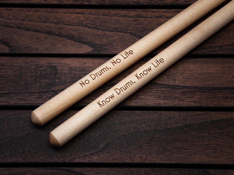 May include: Two wooden drumsticks with the text "No Drums, No Life" and "Know Drums, Know Life" engraved on them.