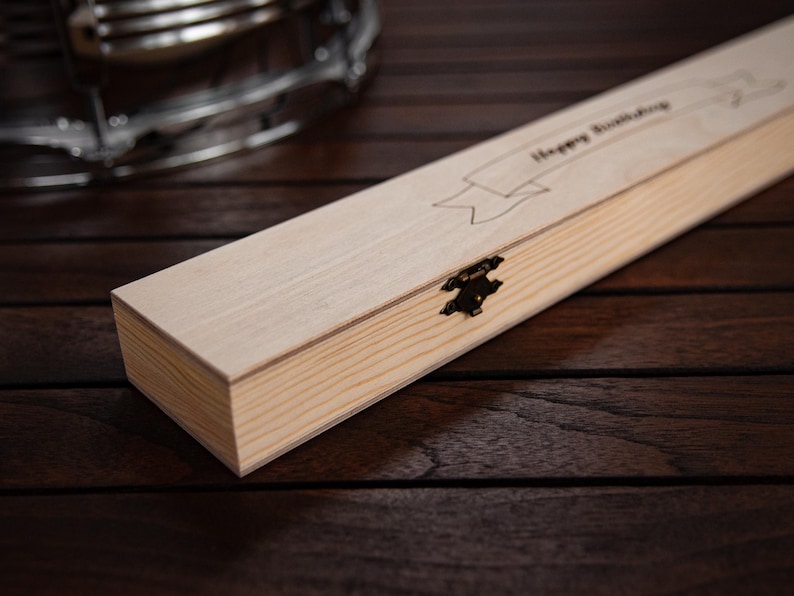 May include: A wooden box with a hinged lid and a brass clasp. The box is engraved with the words "Happy Birthday".
