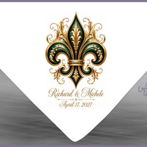 May include: A white triangular card featuring a central dark green and gold fleur-de-lis emblem. Below the emblem, the text reads Richard & Michele in a cursive font, followed by the date April 17, 2027. The logo Lagniappe Life is visible.