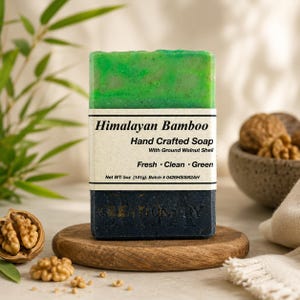 May include: A rectangular bar of soap with a green top layer and a dark charcoal bottom layer. The label reads Himalayan Bamboo Hand Crafted Soap With Ground Walnut Shell Fresh Clean Green Net WT: 5oz (141g). Batch # 0426HS0082AH.