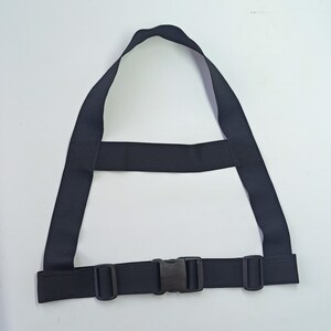 May include: A black adjustable strap with a buckle closure. The strap is made of a thick, durable material and is designed to be worn around the waist or chest.