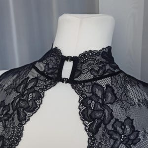 Pode incluir: Top de renda preta com decote alto e fecho de gancho e olho nas costas.