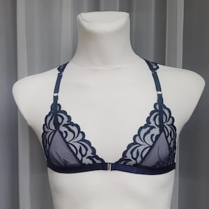 Könnte beinhalten: Ein marineblaues Spitzen-Bralette mit verstellbaren Trägern und einem Haken- und Ösenverschluss im Rücken.