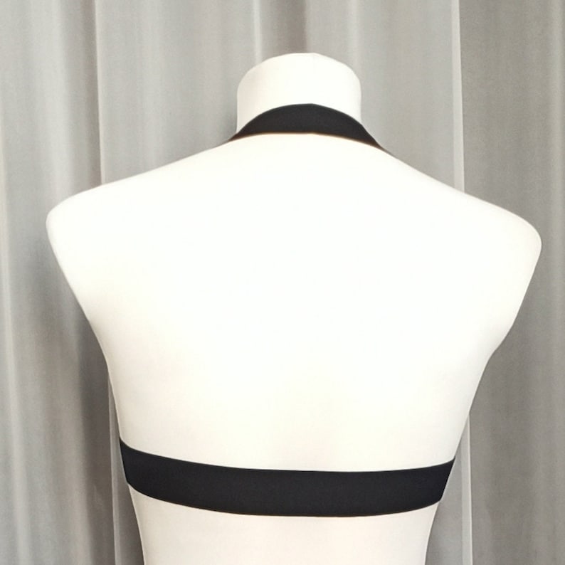 May include: A black halter top with a wide band across the chest.