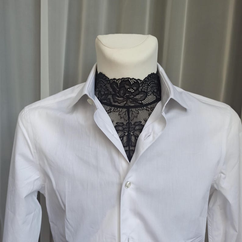 Pode incluir: Uma camisa branca de bot&otilde;es com uma gola de renda preta.