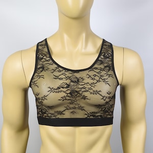 Könnte beinhalten: Ein schwarzes Spitzen-Crop-Top mit Blumenmuster auf einer transparenten Netzbasis. Das Kleidungsstück hat einen Rundhalsausschnitt, breite Schulterträger und ein durchgehendes schwarzes Gummiband am unteren Saum. Das Design ist ärmellos.