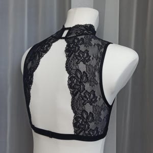 Pode incluir: Top halter preto de renda com costas de olho de fechadura e gola alta.