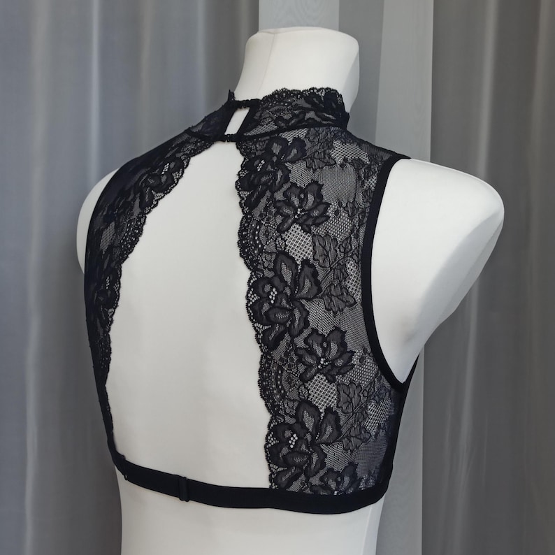 Pode incluir: Top halter preto de renda com costas de olho de fechadura e gola alta.
