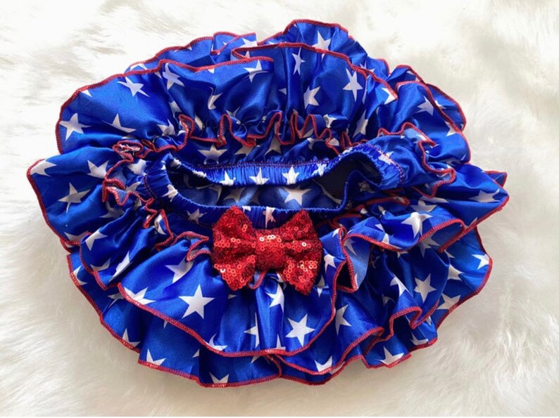 May include: Blue and white star print ruffled bloomers with a red sequin bow.