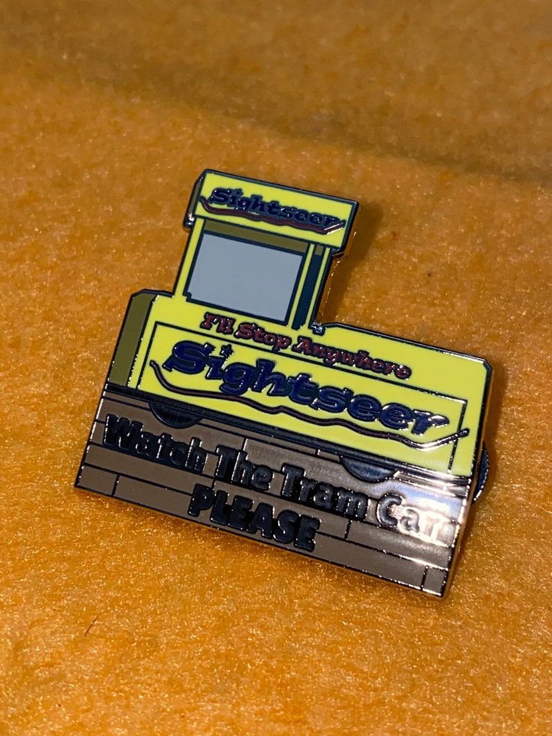 Puede incluir: Pin amarillo y plateado con forma de vag&oacute;n de tren. El pin tiene la palabra "Sightseer" y el texto "I'll Stop Anywhere" y "Watch The Train Car PLEASE".
