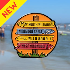 Pu&ograve; includere: Una spilla smaltata colorata con un cartello stradale con quattro frecce direzionali che puntano verso diverse localit&agrave;: North Wildwood, Wildwood Crest, Wildwood e West Wildwood. Il cartello stradale &egrave; su uno sfondo color tramonto con erba verde.