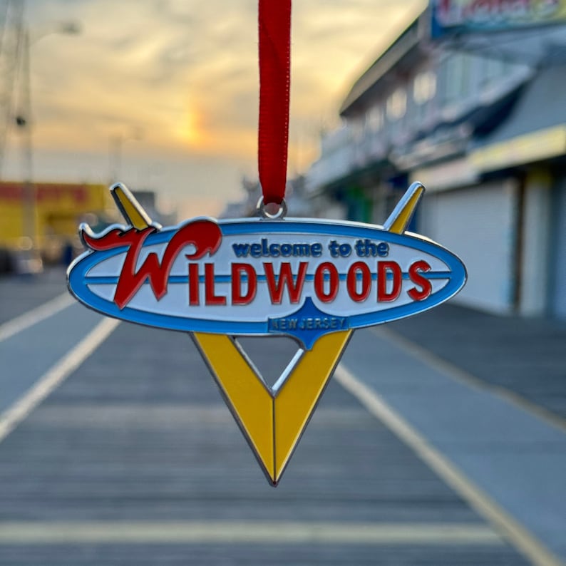 May include: A blue, yellow, and red metal ornament with the text "Welcome to the Wildwoods, New Jersey".