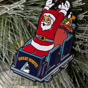 May include: A red and white Santa Claus ornament riding a blue and white roller coaster with the words "Great White" on the side. The ornament is hanging from a red ribbon.