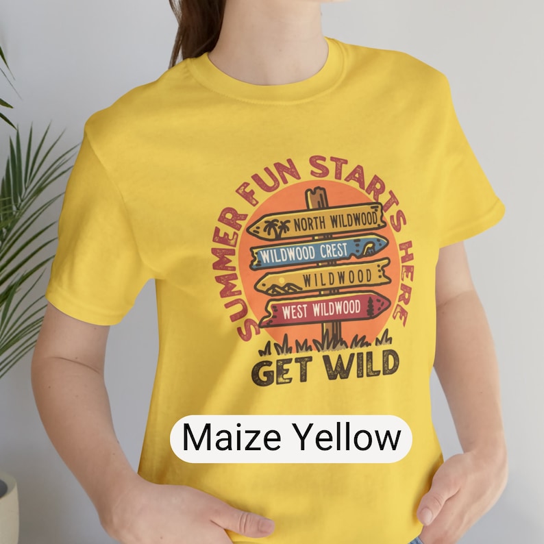 Pu&ograve; includere: T-shirt giallo mais con grafica circolare con la scritta "Summer Fun Starts Here" e "Get Wild". La grafica presenta segnali direzionali per North Wildwood, Wildwood Crest e West Wildwood. La maglietta &egrave; a girocollo e maniche corte.