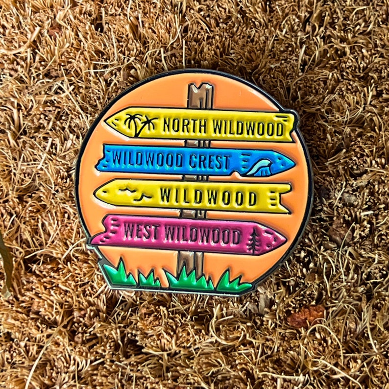 Pu&ograve; includere: Uno spillo smaltato colorato con un cartello stradale con quattro frecce direzionali che puntano a diverse localit&agrave; a Wildwood, nel New Jersey. Le frecce indicano "North Wildwood", "Wildwood Crest", "Wildwood" e "West Wildwood".