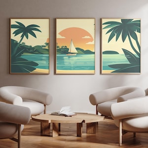 May include: Three framed art prints showing tropical beach scenes. Each print depicts a different view of a beach with palm trees, water, and a sunset. The prints are displayed above a set of curved, cream-coloured armchairs.