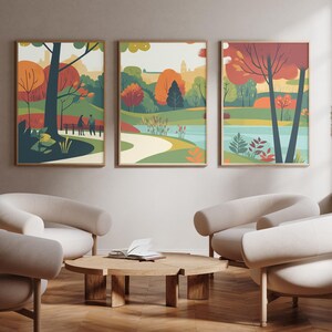 May include: Three framed illustrations of autumnal scenes in a living room. The illustrations feature trees, a lake, a path, and people walking. The frames are brown wood and the illustrations are in a retro style.
