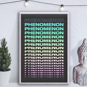 Puede incluir: Un póster en blanco y negro con la palabra "PHENOMENON" repetida en un degradado de colores, desde azul claro hasta rosa. El póster está enmarcado y colgado en una pared blanca.