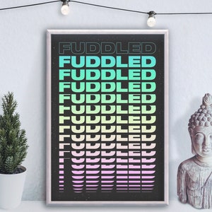 May include: A black and white poster with the word "FUDDLED" repeated in a gradient of green, blue, and pink colors. The poster is framed in a silver frame.