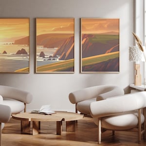 Puede incluir: Tres impresiones enmarcadas de paisajes que representan una escena costera con acantilados y océano. Las impresiones están en una sala de estar moderna con sillones blancos y una mesa de café de madera.