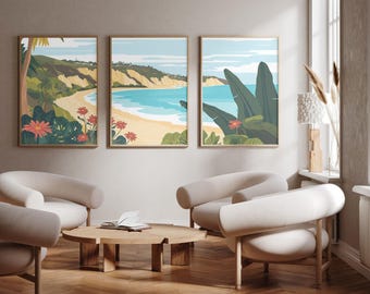 May include: Three framed wall art prints depicting a coastal landscape with sandy beaches, turquoise ocean water, rolling hills, and tropical foliage including large green leaves and red flowers, arranged in a horizontal triptych display.