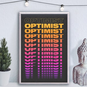 May include: A black and white poster with the word "OPTIMIST" repeated in a gradient of pink, orange, and yellow. The poster is framed in a silver frame and is hanging on a white wall.