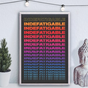 May include: A black and white poster with the word "Indefatigable" repeated in a gradient of colors, including yellow, orange, red, pink, purple, and blue. The poster is framed in a white frame and is hanging on a white wall.