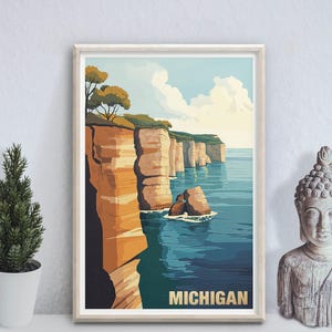 May include: A framed art print featuring a scenic view of the Michigan coastline. The artwork depicts towering cliffs in shades of orange and brown, with green vegetation at the top, overlooking a blue lake. The word "MICHIGAN" is printed at the bottom.