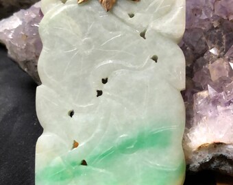 May include: A green jade pendant with a carved floral design and a gold leaf bail.