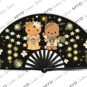 May include: A black folding fan with a gold and white design. The fan features two cartoon characters, a cat and a dog, dressed in traditional Filipino clothing. The background is black with gold stars and white flowers.